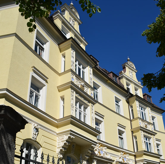 Außenfassade eines Mehrfamilienhauses mit gelben Anstrich